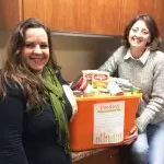 Two ladies from RPM Today with food drive box.