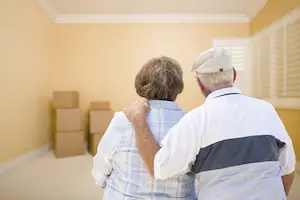 Older couple looking at boxes in empty room